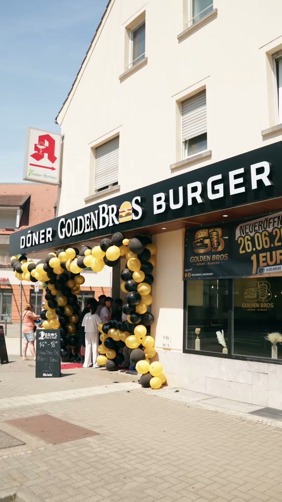 Laden von außen am Eröffnungstag, mit schwarzen und goldenen Ballons